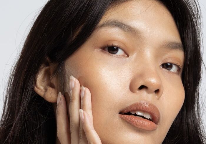 woman holding smooth face after facial