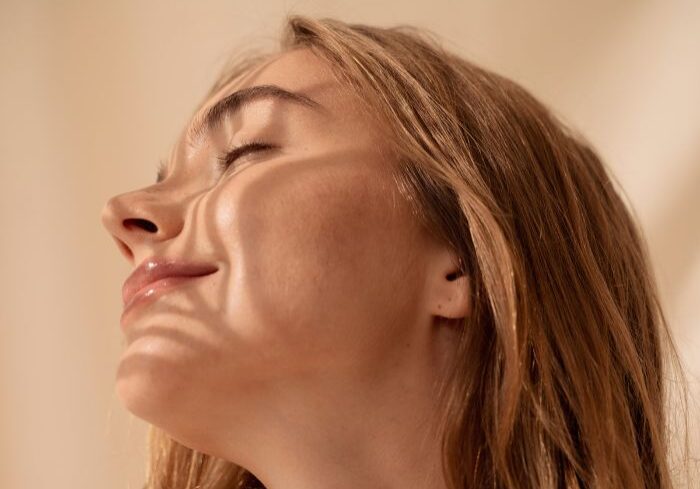 woman smiles in the sunshine with natural looking rows and lashes